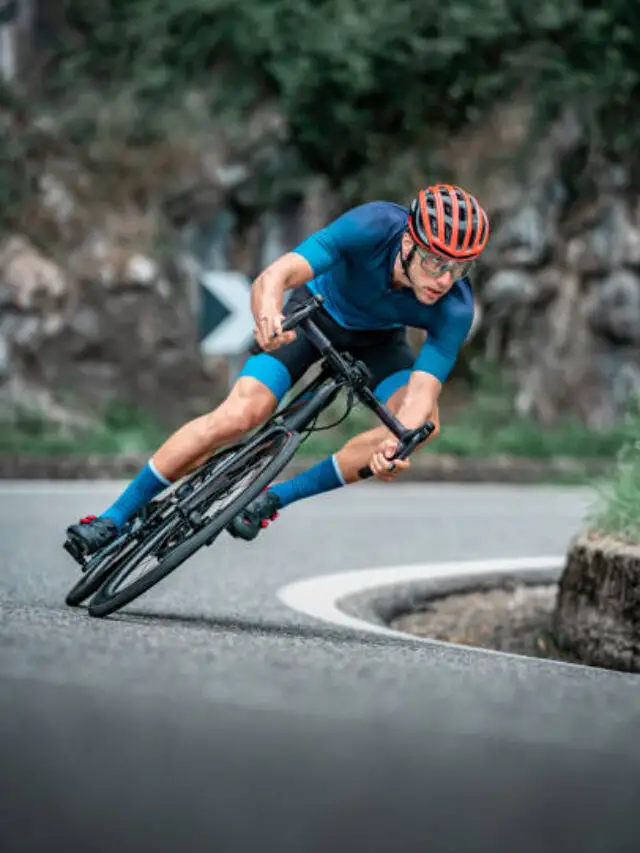 Bicycle racing cyclist on asphalt road curve