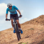 Mountain biker cycling, training and going up a steep climb.