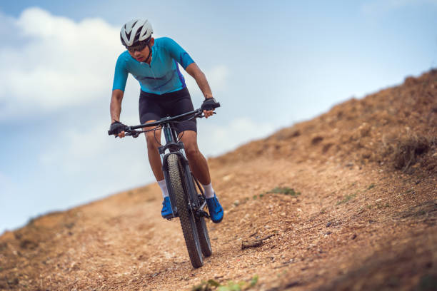 Mountain biker cycling, training and going up a steep climb.